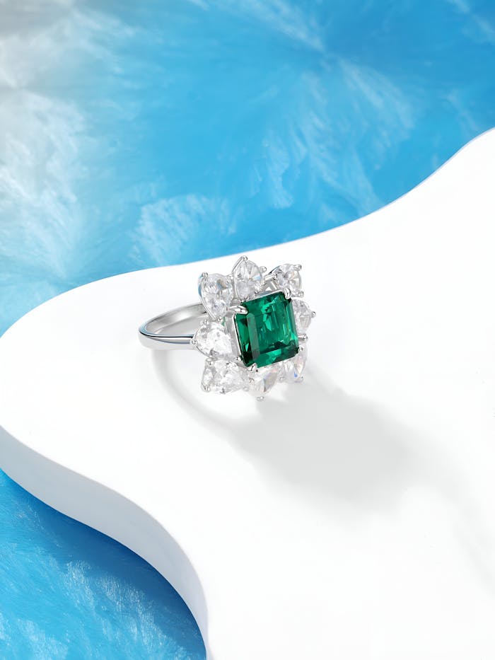 Elegant emerald-cut ring with diamond accents, showcasing luxury in a modern design.